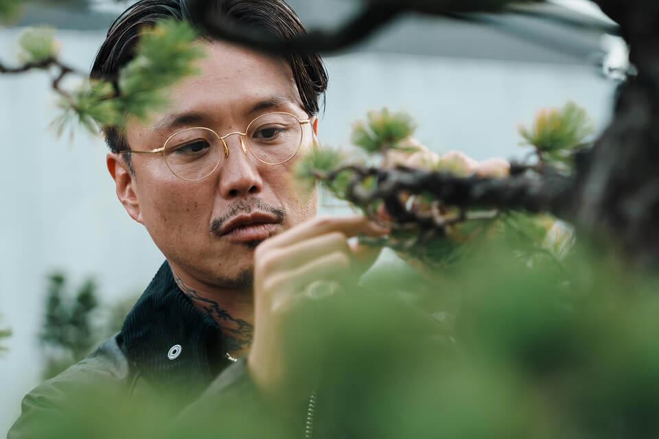 盆栽の手入れをする「TRADMAN’S BONSAI」創業者・CEOの小島鉄平さん アップ