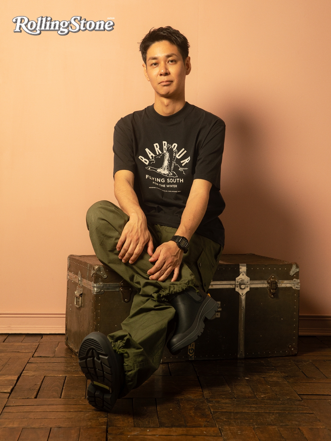 黒いTシャツとカーキパンツ、サイドゴアブーツを着用したNAOTOの写真